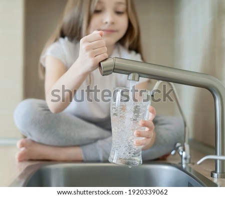 Little child open water tap. Kitchen faucet. Glass of clean water. Pouring fresh drink. Hydration. Healthy lifestyle. Good habit. Water quality check. World water monitoring day. Plastic free concept
