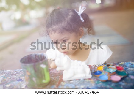 Similar – Funny child looking at the camera and painting