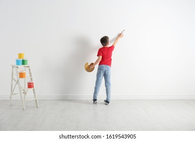 Little child painting on blank white wall indoors - Shutterstock ID 1619543905
