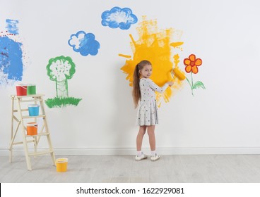 Little Child Painting Wall With Roller Brush Indoors