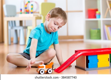 Little child playing with a toy car in nursery