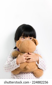 Little Child In Pyjamas Holding Teddy Bear