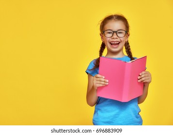 Little Child Is Reading A Book. Kid On The Background Of Bright Color Wall. Education And Success Concept. Yellow, Red And  Blue.