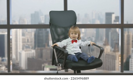 Little child with red bow sit on rotating chair, window  city panorama - Powered by Shutterstock