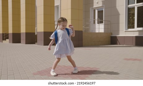 Little Child With School Backpack Having Fun Spin In School Yard, Happy Dreamy Kid, First Grader Loves To Play Dizzying Games, Fun Game For Childhood, Education And Development Preschool Age