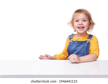 Little Child Sitting At White Table Empty Copy Space Background.Kid Girl Portrait Advertisement Place Design.