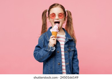 Little child smiling cute kid girl 7-8 years old wears denim shirt glasses have fun eat ice cream close eyes isolated on plain pastel light pink background. Mother's Day love family lifestyle concept - Powered by Shutterstock