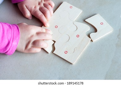 Little child solving a puzzle.