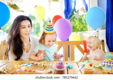 Little child and their mother celebrate birthday party with colorful decoration and cakes with colorful decoration and cake. Family with sweets, candy and festive gifts. Boy and girl birthday party.