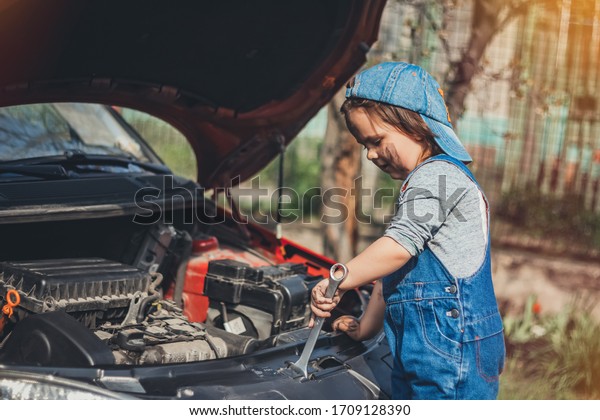 Little child trying to fix broken real car.\
Dreaming to be auto\
technician