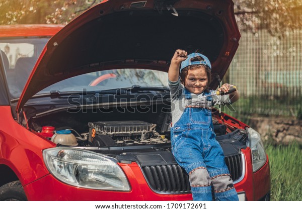 Little child trying to fix broken real car.\
Dreaming to be auto\
technician