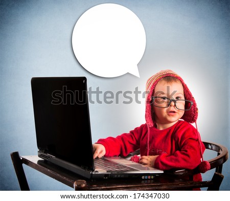 Little child typing on laptop computer and blank bubble speech