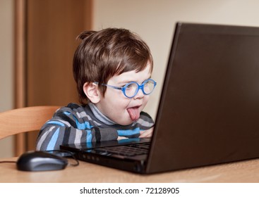 Little Child Using A Computer With His Tongue Out