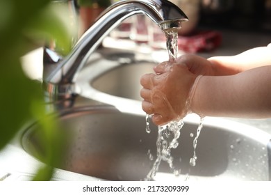 Little child washing hands in kitchen, closeup view - Shutterstock ID 2173209399