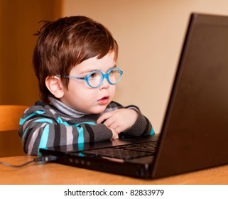 Little child wearing glasses using computer