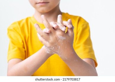 A Little Child In A Yellow T-shirt Is Washing His Hands. Close Up.