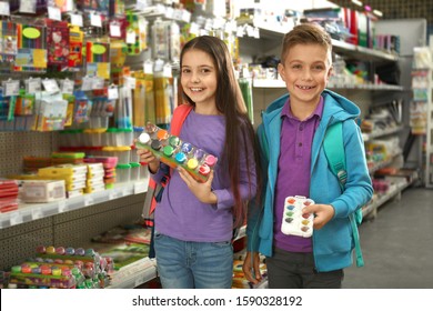 Little children choosing school stationery in supermarket