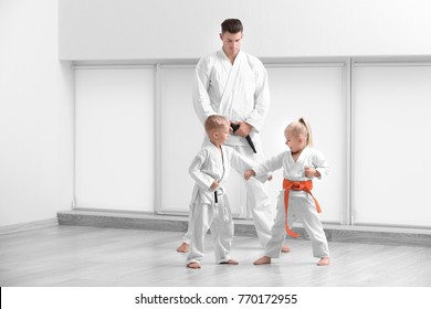 Little children with instructor practicing karate in dojo - Powered by Shutterstock