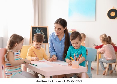 Little children with kindergarten teacher drawing at table indoors. Learning and playing - Shutterstock ID 1504973153