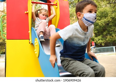 Little Children With Medical Face Masks On Playground During Covid-19 Quarantine