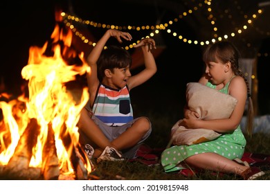 Little children near fire on summer evening