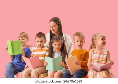 Little children with nursery teacher reading books on pink background - Powered by Shutterstock