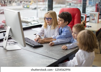 Little Children On Business Meeting Sharing Ideas In Office And Using Computer.