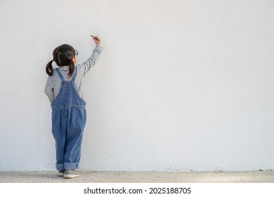 Little children painting white wall