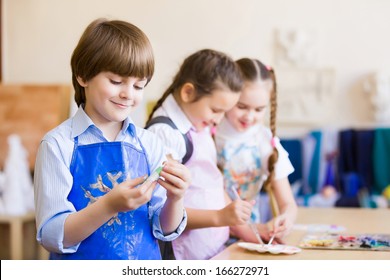 Kleine Kinder, die im Kindergarten malen und spielen
