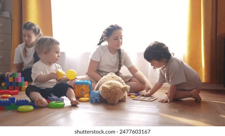 little children play at home. happy and full of joy childhood, children's dream concept. a group of children of different ages are playing in the room, various colorful toys lie nearby lifestyle - Powered by Shutterstock