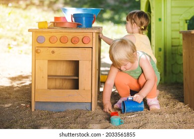 Little children playing outdoors in play kitchen - Powered by Shutterstock