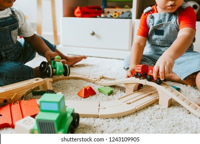 Little children playing with a railroad train toy