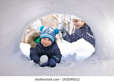 Little Children Playing With Snowballs In Snow House