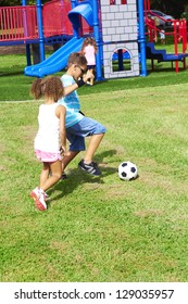 Little Children Playing With Soccer Ball At Park. Vertical Shot.