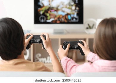 Little children playing video game at home, back view - Powered by Shutterstock