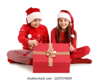 Little children in Santa hats opening Christmas gift on white background - Powered by Shutterstock