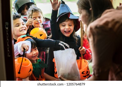 Little children trick or treating on Halloween - Shutterstock ID 1205764879