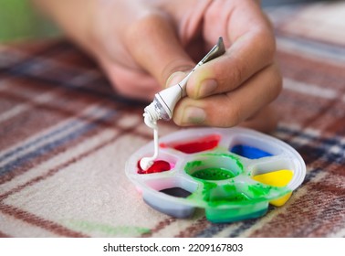 Little Children's Hands Are Mixing Color Into The Palette. Preschool Children Prepare Paint For Art Work.