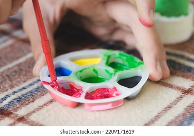 Little Children's Hands Are Mixing Color Into The Palette. Preschool Children Prepare Paint For Art Work. Selective Focus.