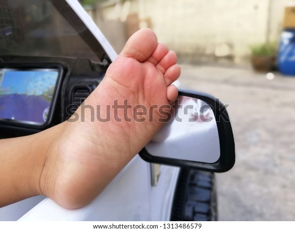 little child\'s foot on a\
big toy car
