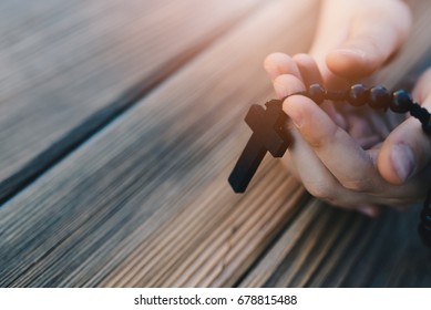 Little Childs Hands Holding Wooden Rosary. Child Praying