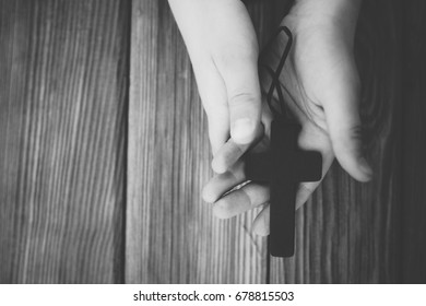 Little Childs Hands Holding Wooden Rosary. Child Praying