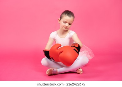 Little Classical Dancer Girl Wearing Boxing Gloves Isolated On Pink Background. Female Stereotypes Concept.