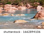 The Little Colorado River runs turquoise blue due to alkali minerals dissolved in its waters on a sunny spring day.