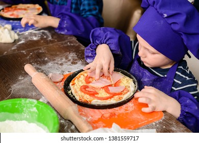 Little cook. Children make pizza. Master class for children on cooking Italian pizza. Young children learn to cook a pizza. Kids preparing homemade pizza - Powered by Shutterstock