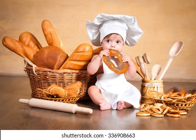 Little Cook. Small Kid In A Chef's Hat With Wicker Baskets Of Pastries, Rolls, Bread And Bagels