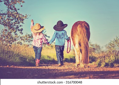 Little Cowboy And Cowgirl Walking Pony