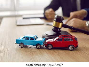 Little crashed autos on table in courtroom. Gavel and two small toy car models on desk in courthouse. Concept of lawyer services, civil court trial, vehicle accident case study, and insurance coverage - Shutterstock ID 2163779337