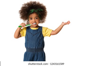 A little cute african american girl brushing her teeth, isolated over white background. Healthy teeth concept. - Powered by Shutterstock