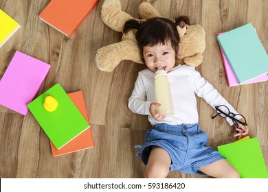 Little Cute Asian Girl Drinking Milk From Baby Bottle, New Family And Baby Healthy Concept